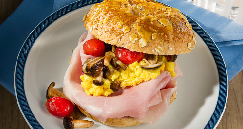 Bagels with cooked ham, scrambled eggs, tomato and browned mushrooms 