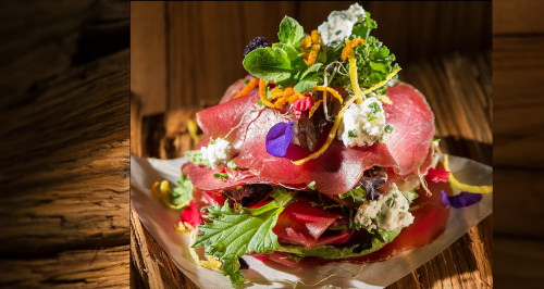 Millefoglie di bresaola con fiocchi di caprino, erba cipollina, insalatina amara e fiori di montagna